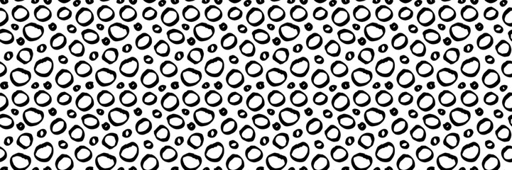 Hand-drawn seamless pattern with irregular black circles and dots on white background. Perfect for wrapping paper, textile print, or bohemian design projects.