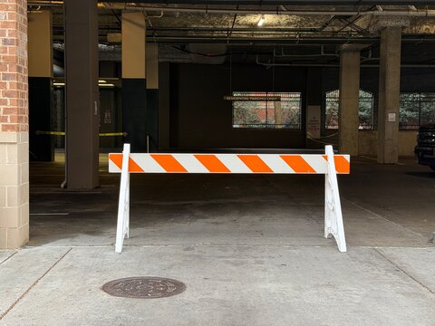 Orange and white do not cross sign barricade to a parking lot
