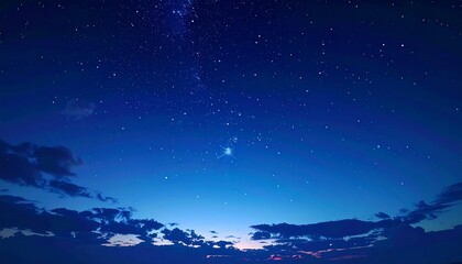 Serene night sky with stars and clouds in deep blue hues.