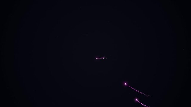Night sky with an aircraft deploying flares or fireworks ascending from below.