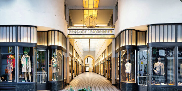 Liege, Belgium September 07 2022: Symmetric view of the elegant Passage Lemonnier entrance in Liege, Belgium, featuring Art Deco style architecture, shop windows, and golden lights