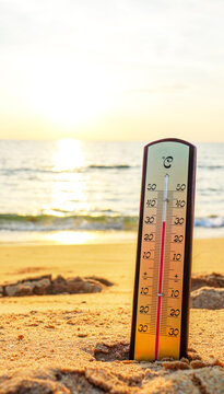 Thermometer on sunset sea beach in tropical. Extremely hot day. Thermometer measuring air temperature. Heat wave weather. Hot weather, drought. Abnormally temperature, extreme heat in Europe. Sunburn.