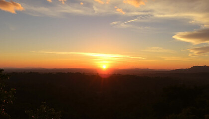 Obraz premium Radiant glowing sunset above jungle horizon