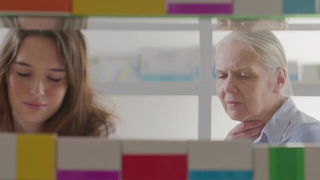 Female Pharmacist Recommending Throat Lozenges to Senior Woman