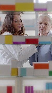Female Pharmacist Recommending Throat Lozenges to Senior Woman