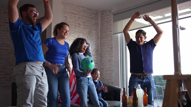 Family and friends cheering and celebrating football soccer at home with a USA flag, smiling together during an exciting match moment. Sports pride, friendship, shared joy, casual home viewing
