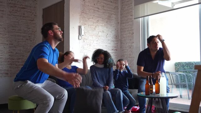 Family and friends on the edge of their seats watching a soccer football match, anticipating a goal attempt, then reacting with disappointment after the missed shot. Sports tension, game night emotion
