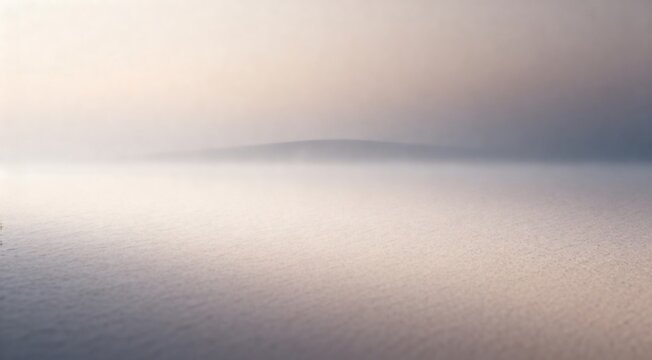 A serene landscape with fog rolling in over the water