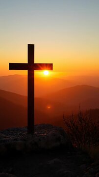 Silhouette of a Christian cross standing on a rocky mountain peak during a vibrant golden sunset with lens flare, symbolizing faith, spirituality, and hope in a serene landscape