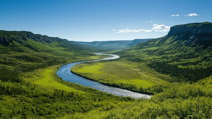 Winding river flowing through lush green valley surrounded by mountains