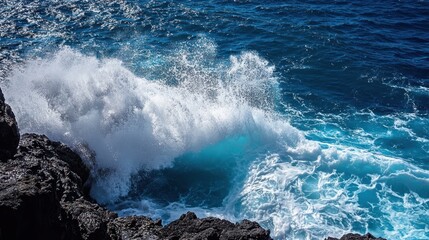 The powerful ocean waves crash against the dark, rocky shoreline, creating a dramatic display of nature's raw energy and beauty with a burst of white foam and spray