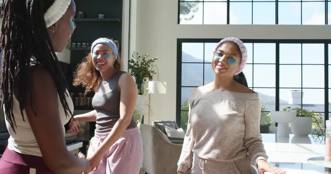 African American women in headbands and eye patches snapping at island after center woman smiling
