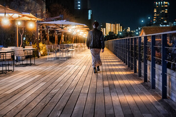 運河沿いのボードウォークを歩く女性