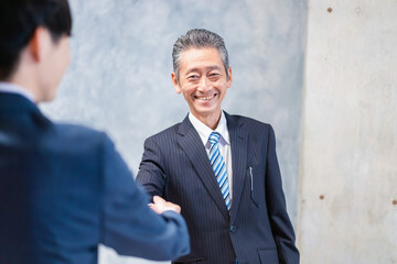 笑顔で握手をするビジネスパーソン