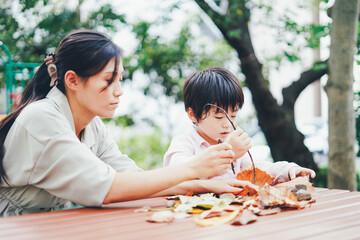 葉っぱで遊ぶお母さんと息子