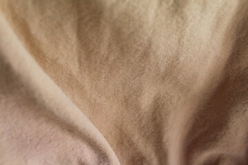 Naklejka premium beige cotton fabric texture.soft folds and wrinkles, neutral textile background, abstract cloth surface.for backdrop, mockup, wallpaper, and design, cover