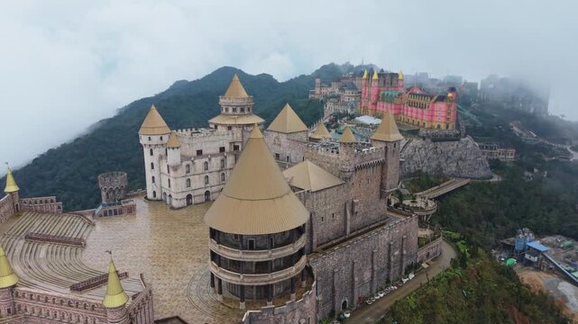 Panoramic Castle Terrace With Colorful Buildings At Ba Na Hills Vietnam, Close Aerial Over Tiled Plaza, Ornate Columns And Spiral Staircases, Decorative Fountains And Visitor Promenade,