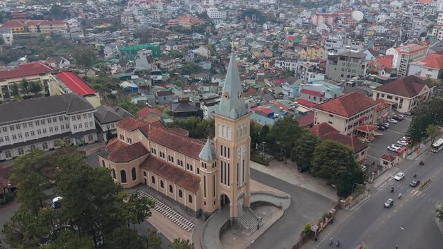 Vertical Screen Aerial Sweep Dalat, Vietnam Cathedral And Streets, Wide Urban Panorama With Moving Vehicles, Busy Avenues, Dense Rooftops, Market Blocks, Steeple Landmark Beside Traffic