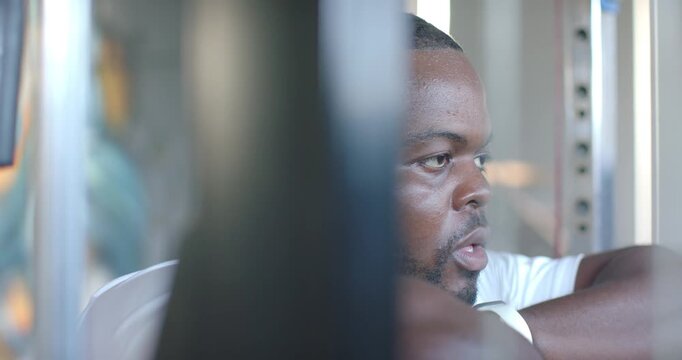 African American man leaning on rack, camera shifting, turning head through bars, recovering
