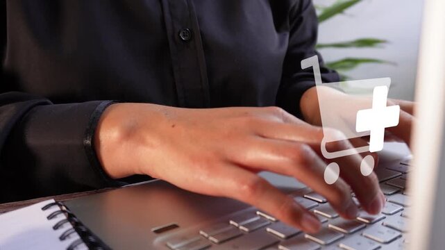 Close-up of a businesswoman working on her computer with an animated shopping cart icon and the "add to cart" button.