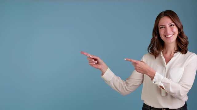 A smiling young woman in a white shirt points with both hands to the left, indicating ample copy space on a solid blue background, representing guidance or promotion.