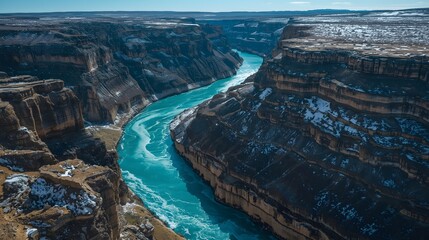 Dramatic Winter Canyon Landscape with Turquoise River Flowing Between Snow Covered Rocky Cliffs
