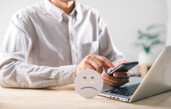 Negative customer feedback signals low satisfaction, bad review posted online using mobile phone and laptop, person expresses unhappy experience, showing overall poor rating or complaint
