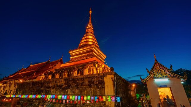 Peaceful nighttime scene of Wat Phaya Phu Phra Aram Luang an ancient Lanna style temple in Nan Province. The illuminated golden stupa and temple structures highlight Buddhist faith and rich heritage