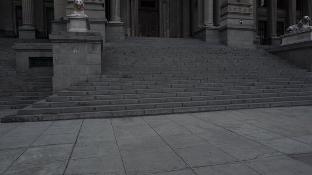 Camera tilts up showing a gray neoclassical building which is called "Palacio de Justicia". The Peruvian Supreme court. Located in Lima, Peru.