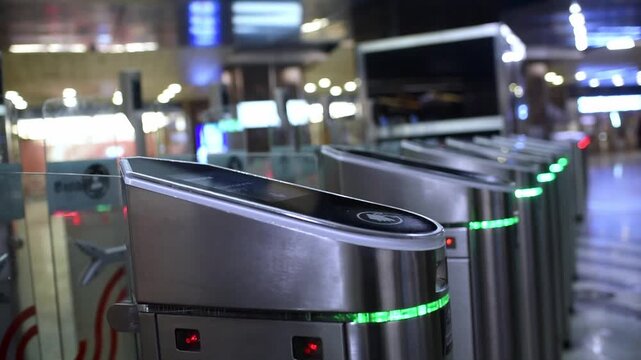 Teenager using contactless card to pass through silver metal turnstile with green light signal at Moscow metro station.