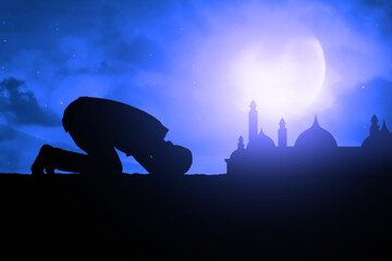 Silhouette of muslim man praying at blue night sky with stars and moon, eid adha mubarak concept