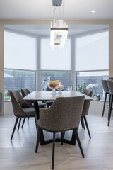 Obraz premium Modern dining room interior with elegant table and designer chandelier