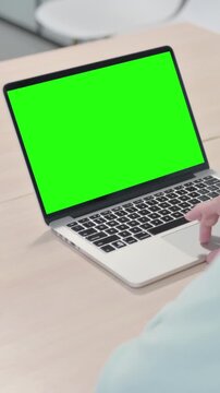 Young Man Using Laptop with Green Screen, vertical video