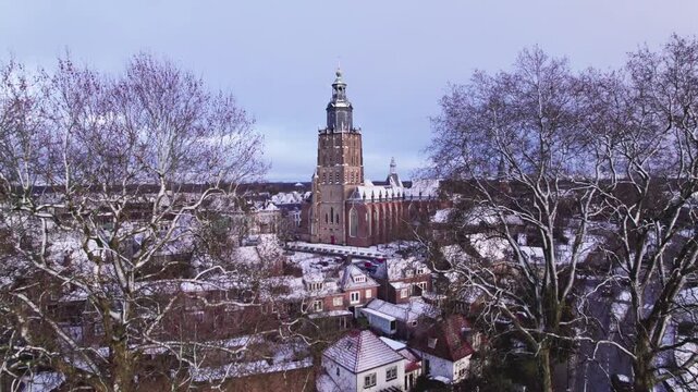 Medieval Hanseatic Dutch tower town Zutphen in the Netherlands covered in snow with historic heritage buildings in the background behind Walburgiskerk church tower