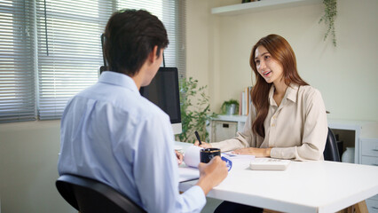 Obraz premium Female consultant reviewing paperwork with a client during a meeting.