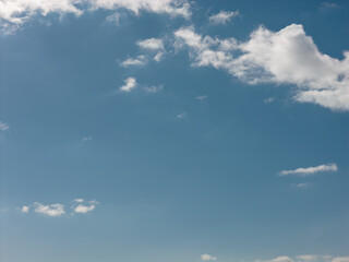 Obraz premium Bright blue sky dotted with white fluffy clouds, a serene open backdrop evoking freedom, fresh air and peaceful weather ideal clean, airy background space for copy