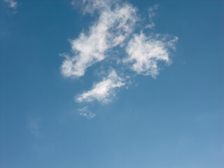 Bright blue sky featuring soft white clouds floating across, creating a peaceful and open natural environment showcasing weather and atmospheric conditions