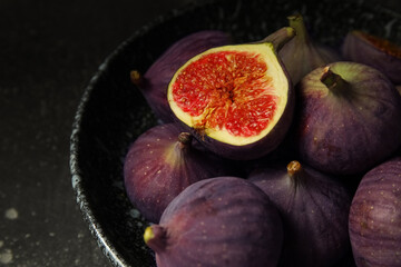 Plate with fresh ripe figs on dark background, closeup