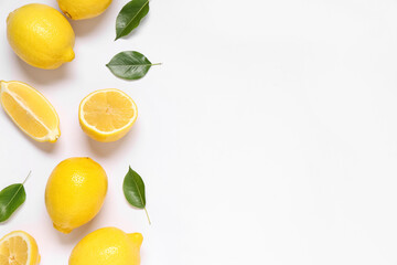 Fototapeta premium Fresh ripe lemons and leaves on grey background