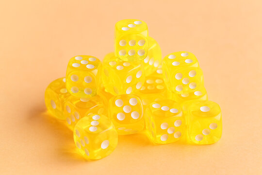 Heap of yellow game dices on orange background
