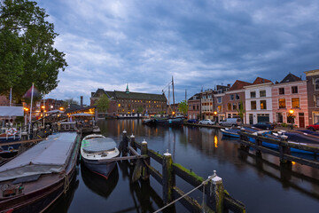 Fototapeta premium Historic Leiden city centrum under twilight with dramaticv sky , The city is intersected by numerous small canals with tree-bordered quays.