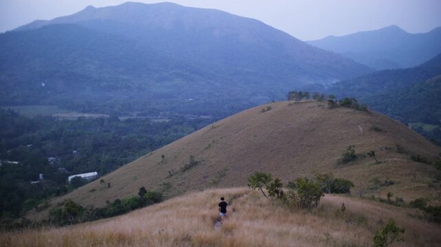 Person Looks Over Rolling Hills and Mountains at Mount Tapyas