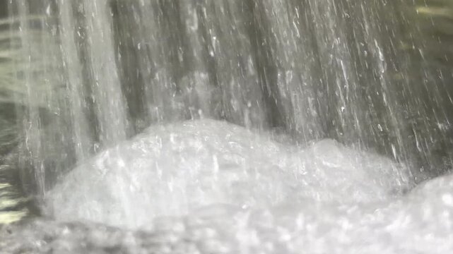 A steady stream of water plunges into a full pot, generating a resonant hum and rhythmic gurgling. overflowing water escapes into the sink, producing the hollow noise of liquid draining into a siphon.