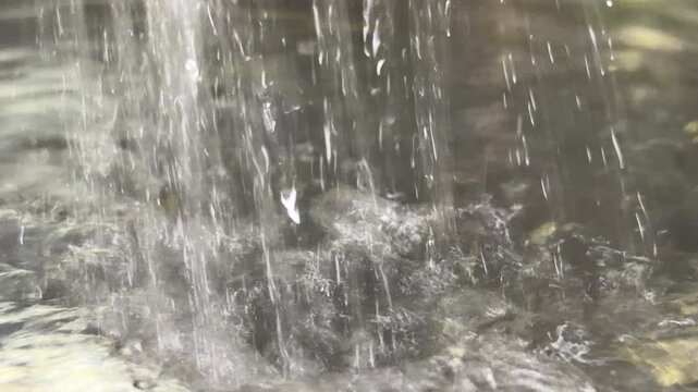 A steady stream of water plunges into a full pot, generating a resonant hum and rhythmic gurgling. overflowing water escapes into the sink, producing the hollow noise of liquid draining into a siphon.