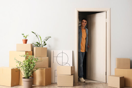 Young man walking through open door in hall on moving day