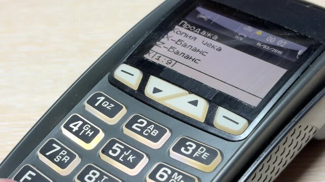 A person presses the tactile keys on a payment terminal to process a transaction. Each physical press creates a soft clicking sound followed by a short electronic beep.