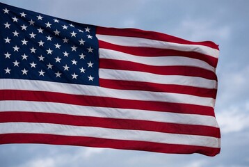 Fototapeta premium Waving united states of america flag with red white and blue colors against cloudy sky