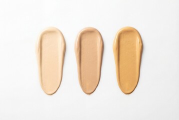 Obraz premium Three shades of beige liquid cosmetic foundation smears arranged on a white background
