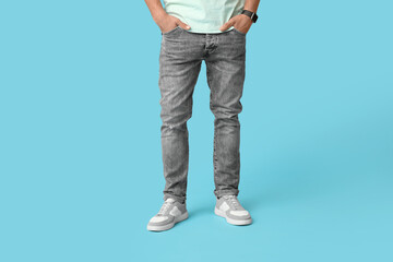 Naklejka premium Stylish man in jeans on blue background