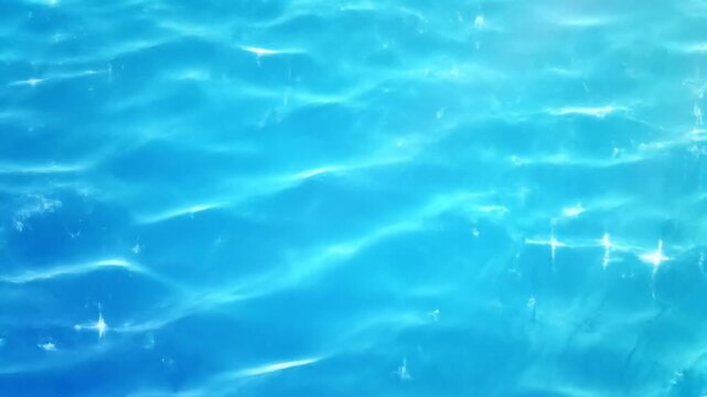 A serene pool scene with gentle ripples reflecting sunlight, viewed from directly above, capturing tranquility and calmness with water, sunlight, ripples, pool, and reflection